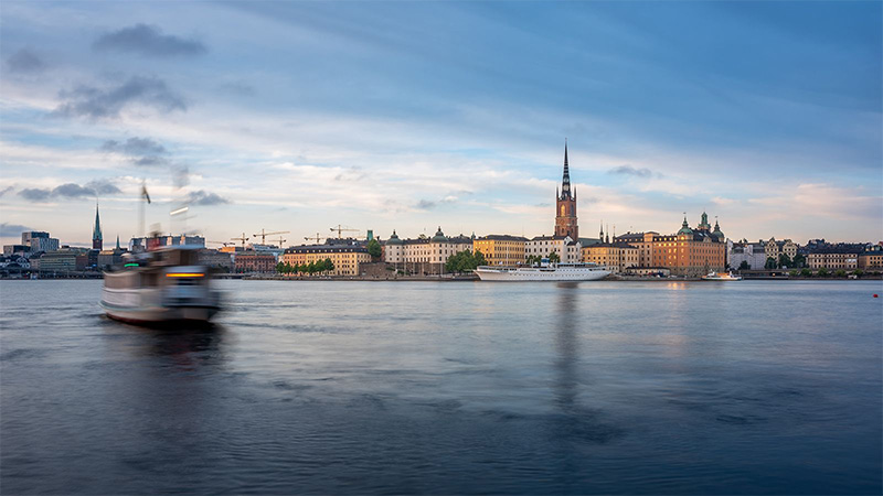 boats on calm river alongside buildings