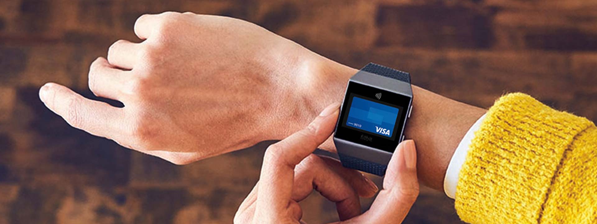 fitbit watch on arm with Visa card on screen