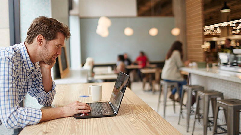 Man paying online via laptop in cafe